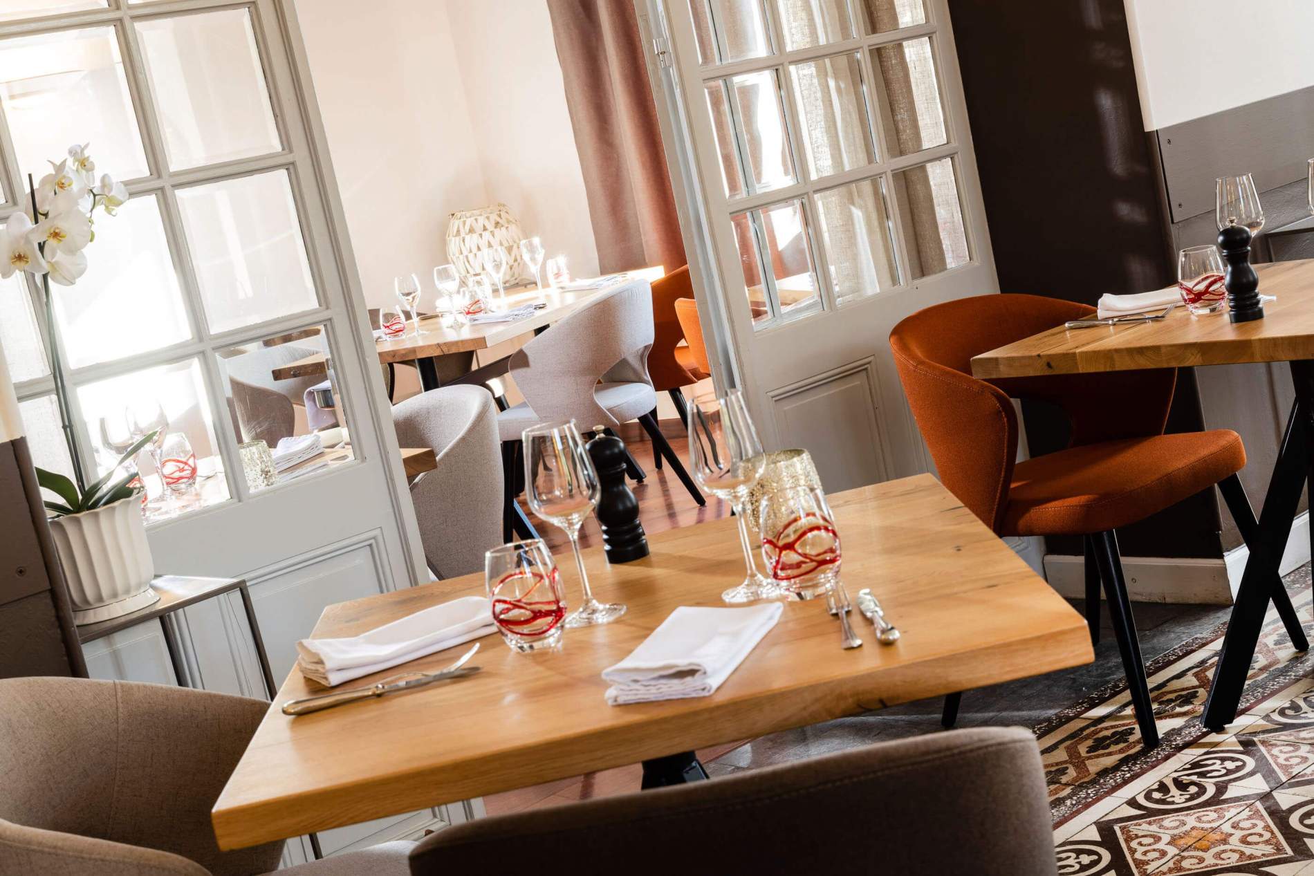 Détail de service : verres soufflés, serviettes blanches et orchidée