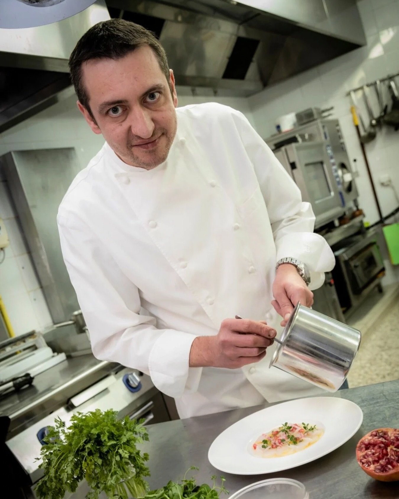 Stéphane Riss dressant un carpaccio de Saint-Jacques en cuisine
